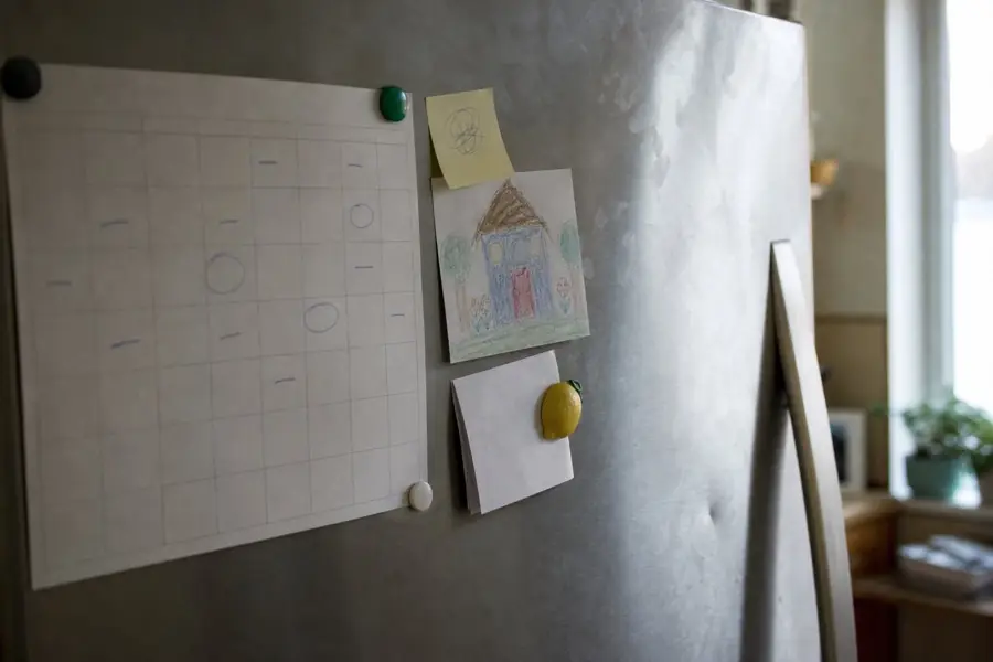 Paper wall calendar with a few days circled in pen, held by magnets on a refrigerator door